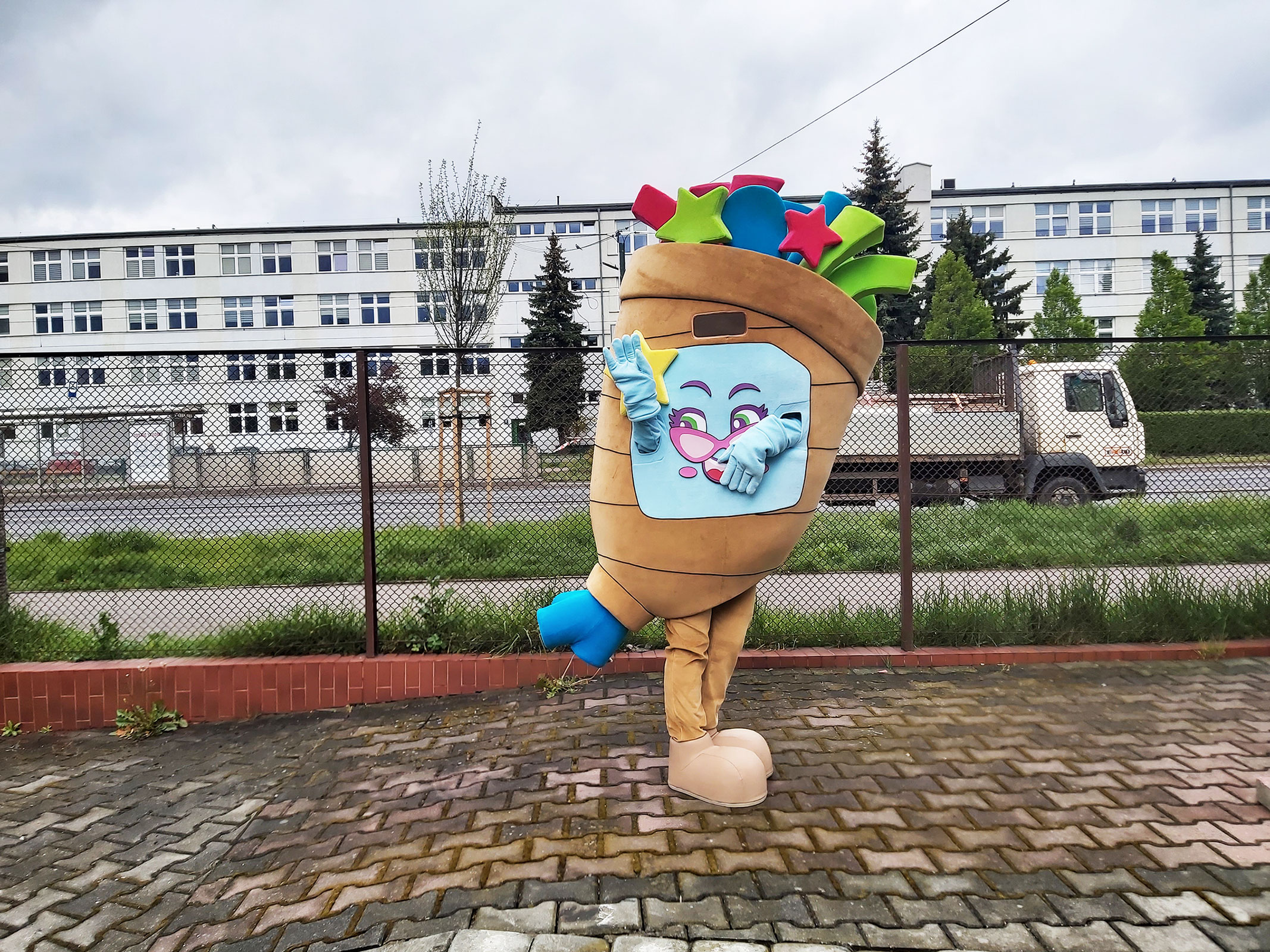 Na fotografii widnieje strój róg obfitości pozujący do zdjęcia przed siedzibą firmy Elabika